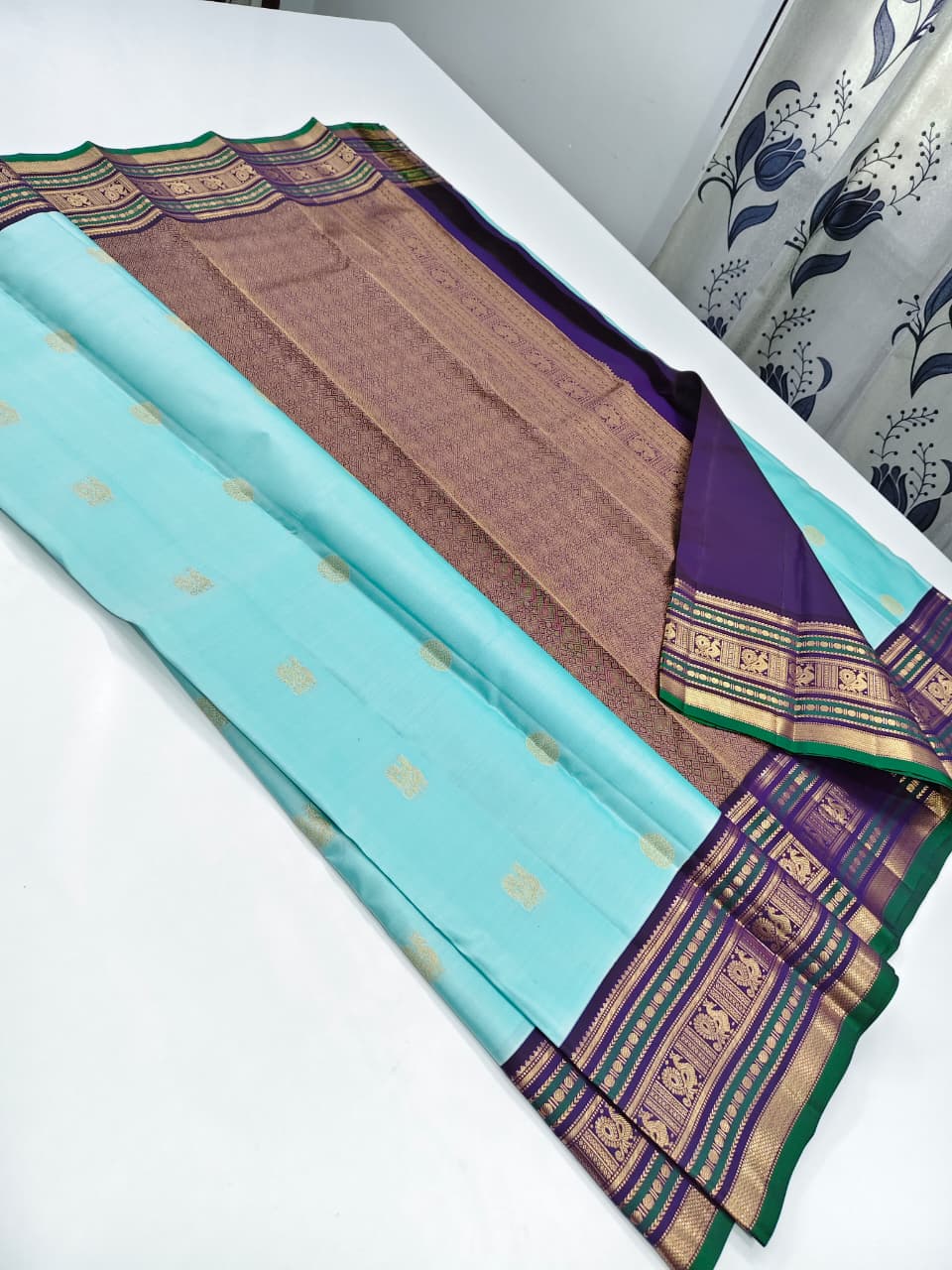 Handloom Kanchipuram Silk Saree with a traditional contrast border and buttas.
